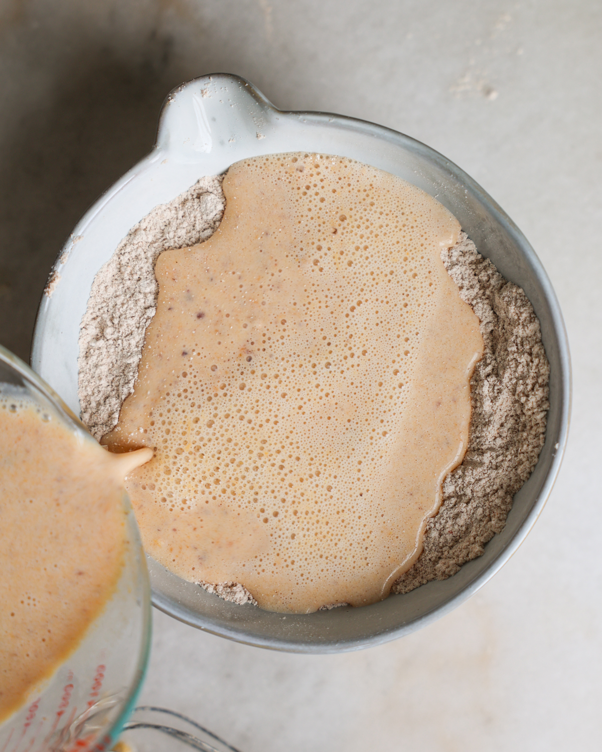 pouring wet ingredients into dry