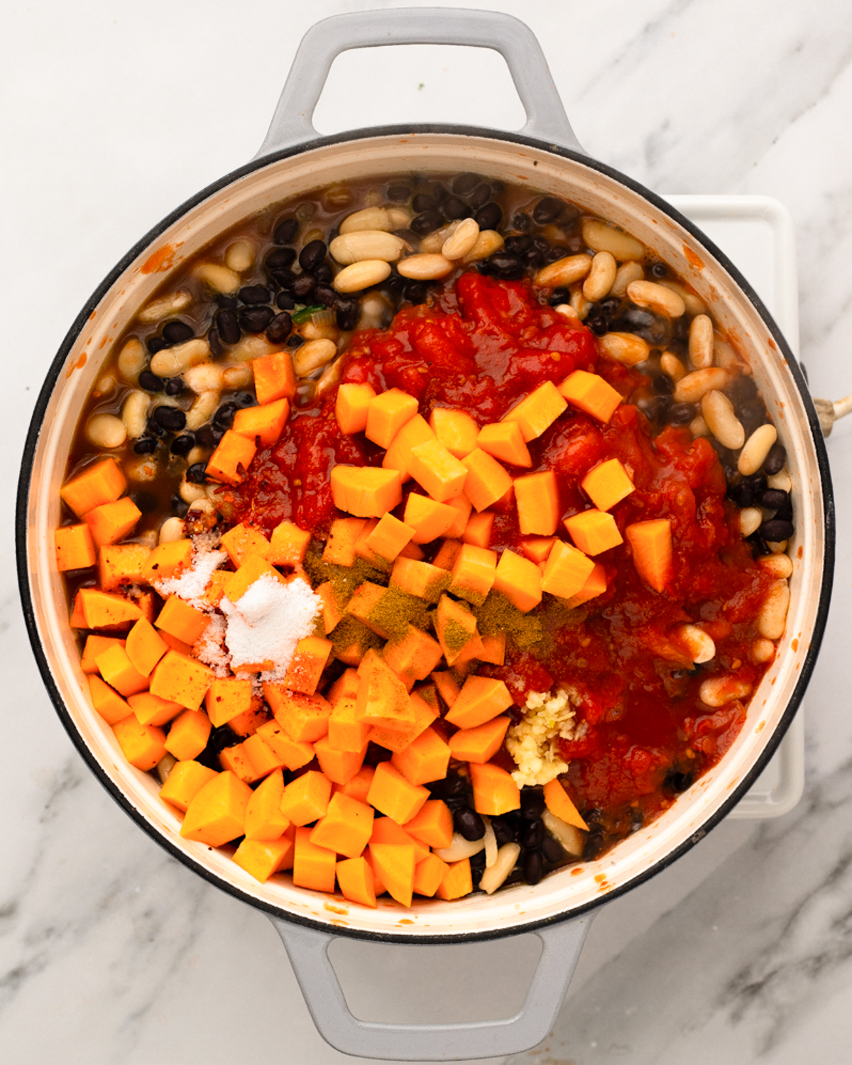 overhead sweet potato and tomatoes added to pot