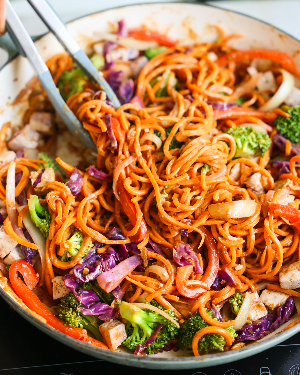 tossing sweet potato noodles