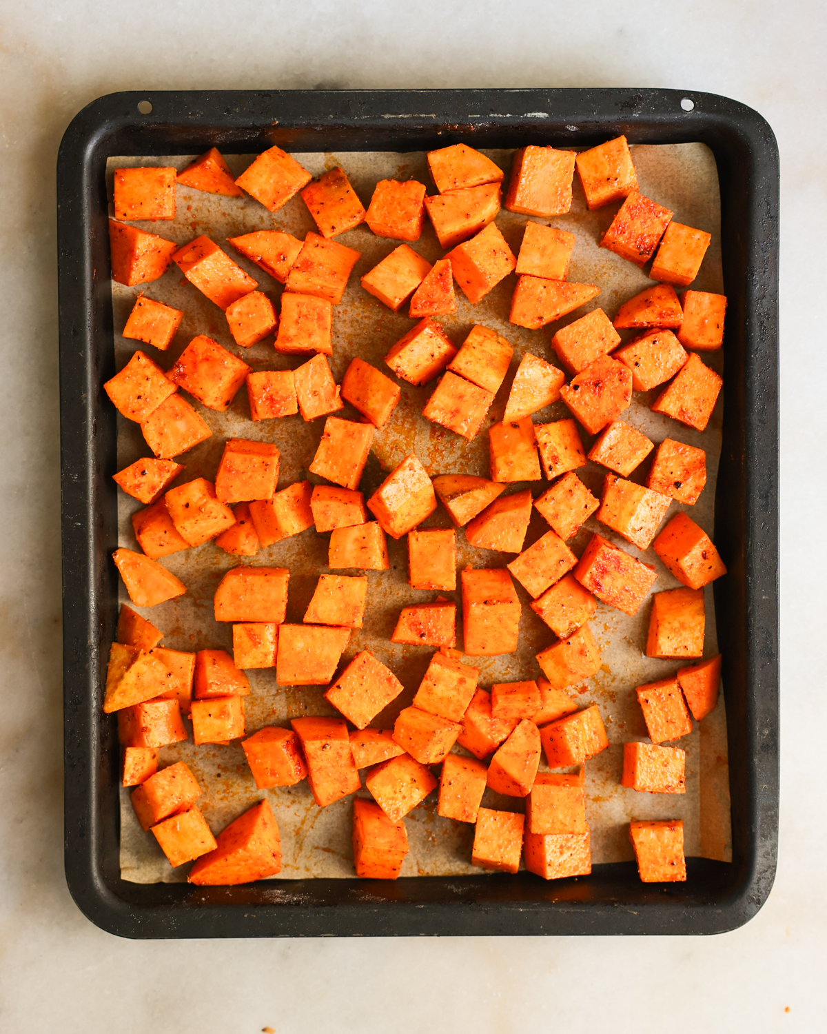 overhead sweet potatoes spread on baking sheet