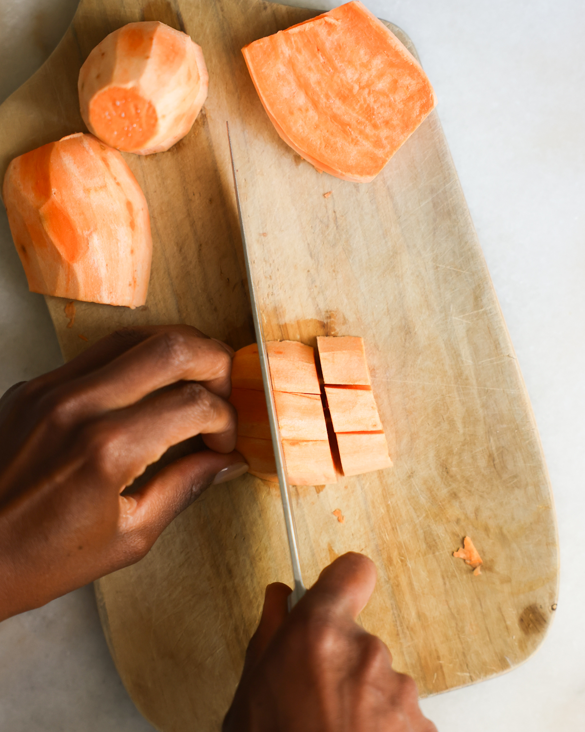 slicing sweet potato into cubes