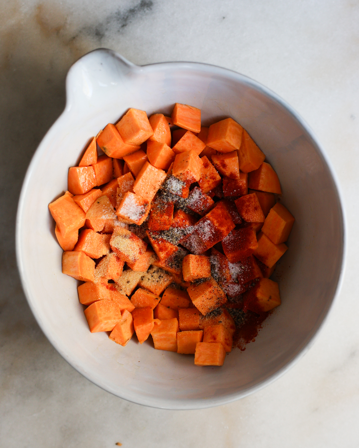 overhead sweet potato cubes with spices added