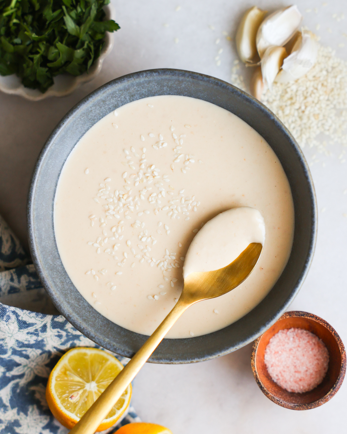 overhead of tahini dressing with spoon in bowl