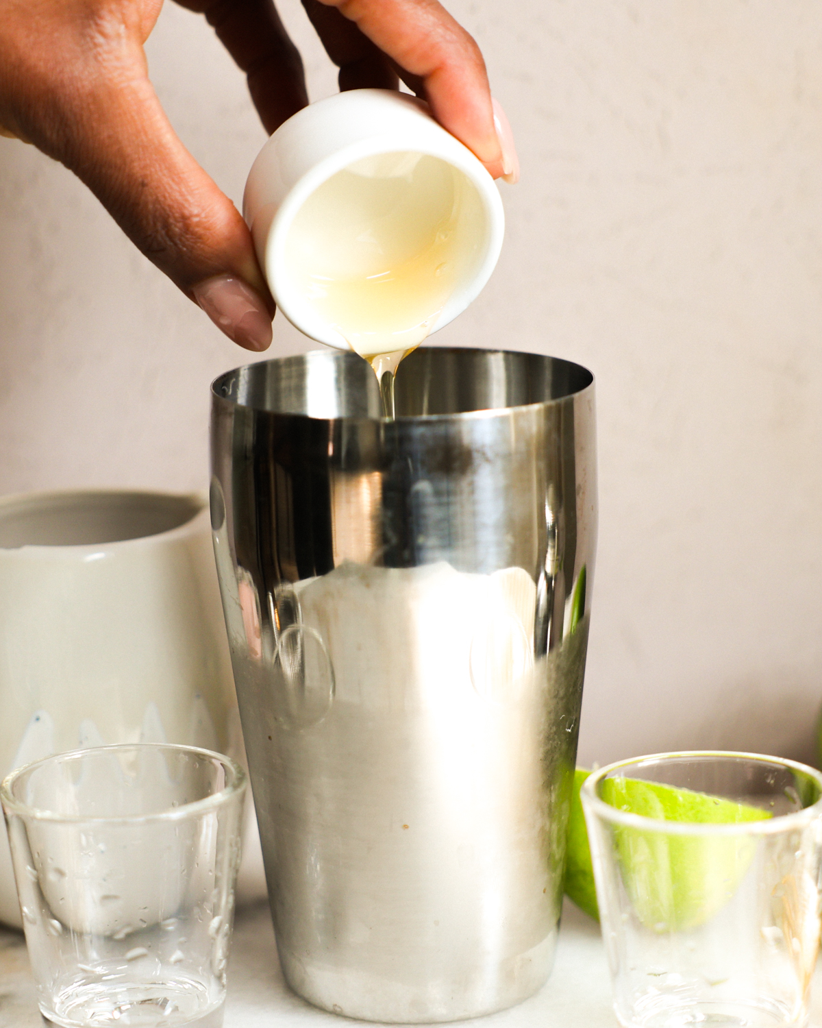 adding ingredients to cocktail shaker