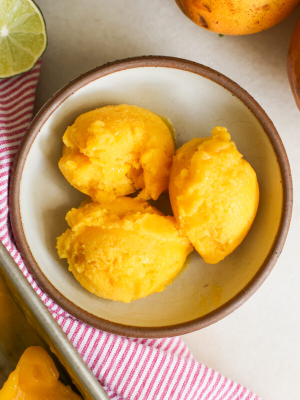 overhead of mango sorbet scoops in a bowl