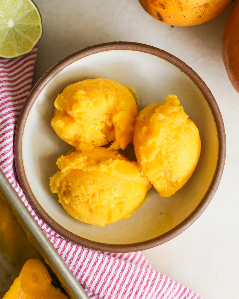 overhead of mango sorbet scoops in a bowl