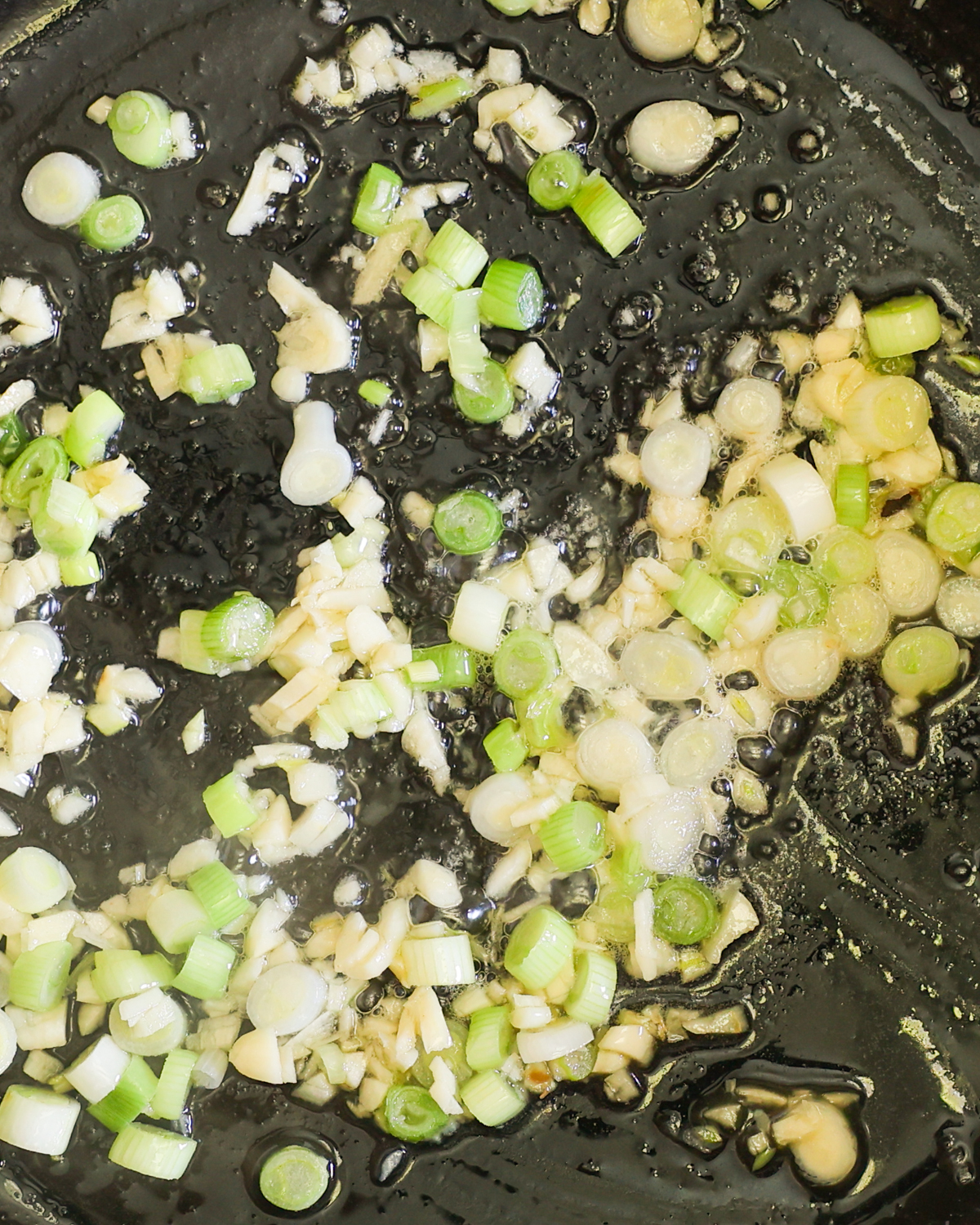 close up sautéeing garlic and scallions