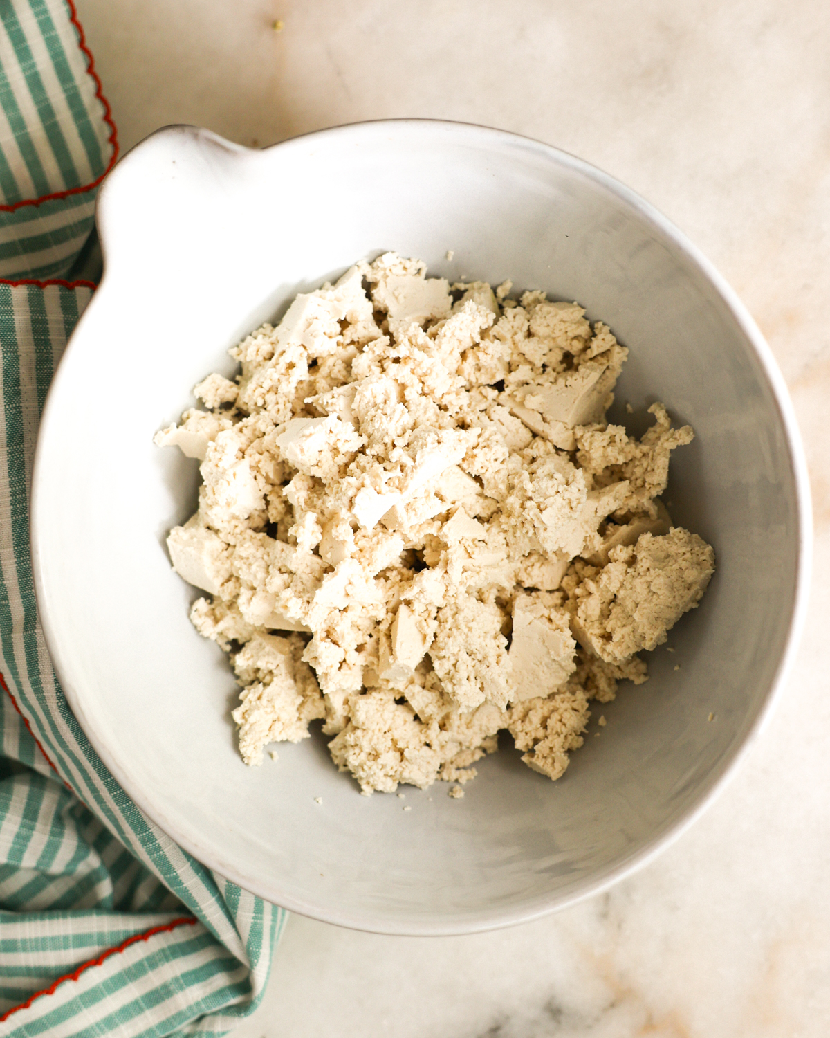 overhead of crumbled tofu in a mixing bowl