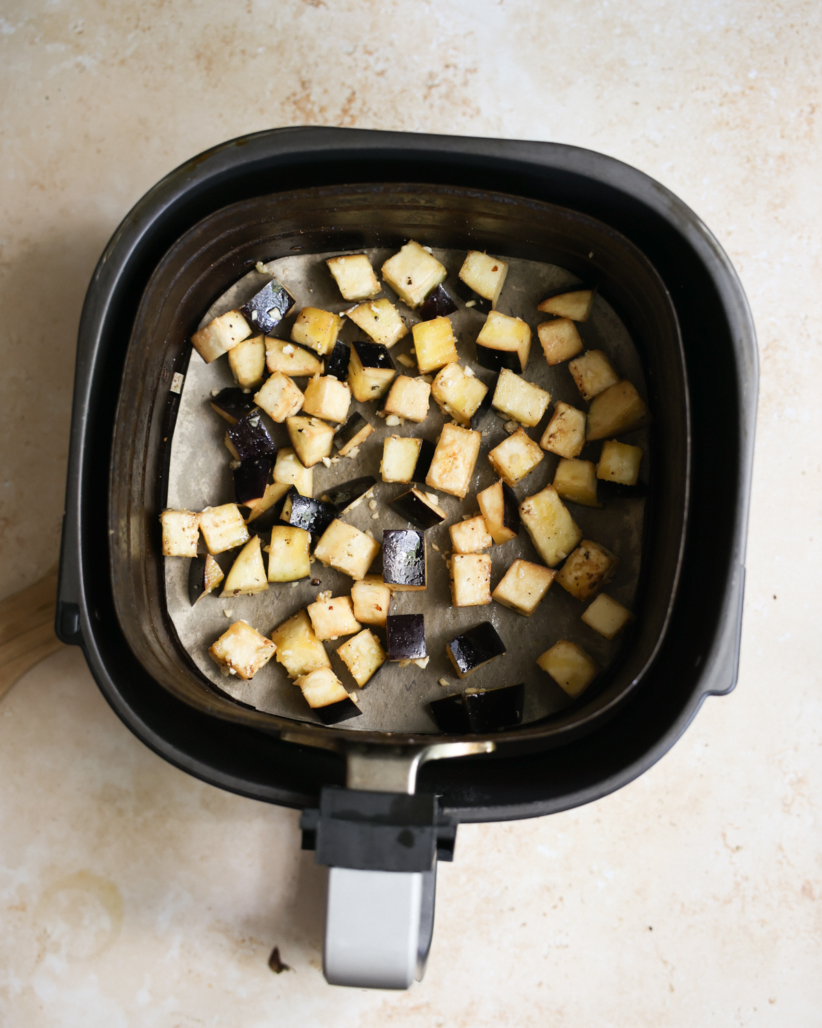 An overhead shot of the eggplant in the air fryer basket before cooking.