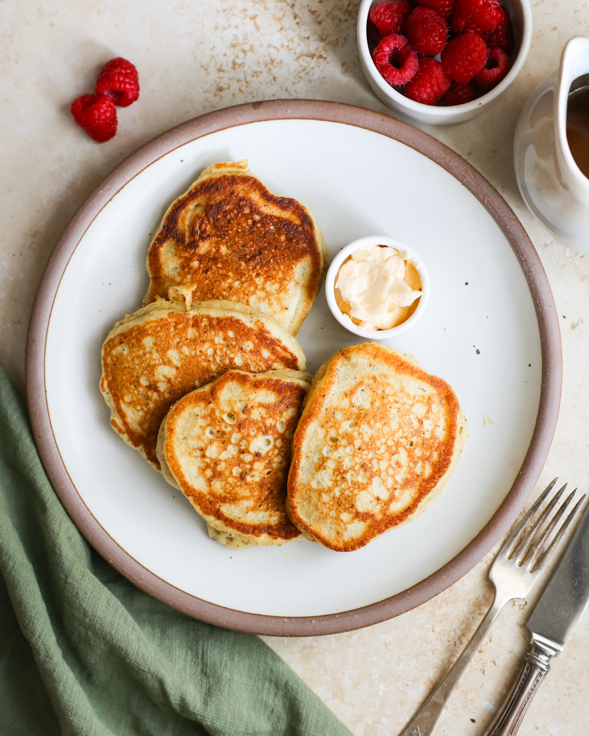 An overhead shot of a plate of sourdough discard pancakes with a small dish of vegan butter.