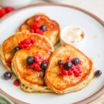 A plate of sourdough discard pancakes with berries.