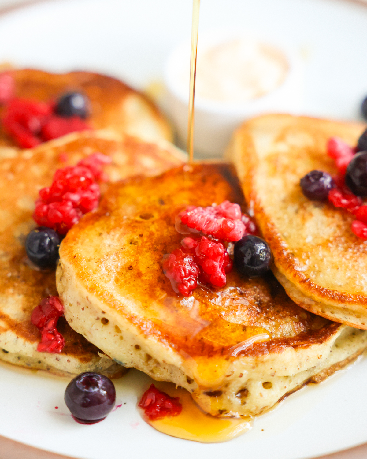 A close-up shot of the sourdough discard pancakes with maple syrup.