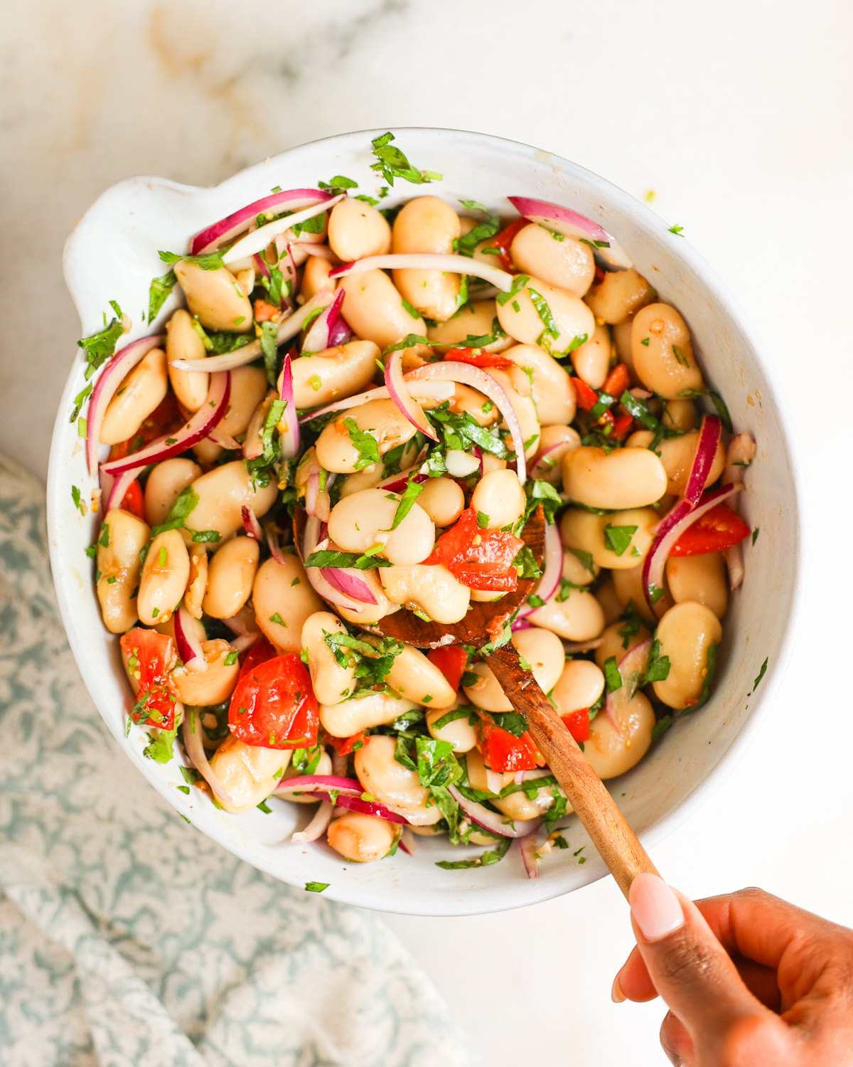 tossed white bean salad in mixing bowl