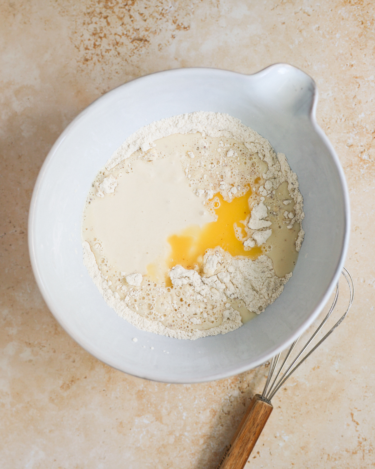 A mixing bowl with the sourdough discard, flour, melted butter, and other pancake ingredients.