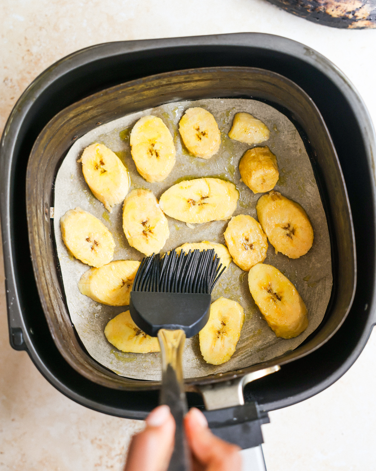 brushing oil on plantains