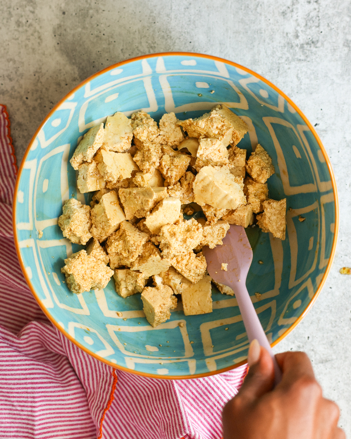 stirring tofu in bowl