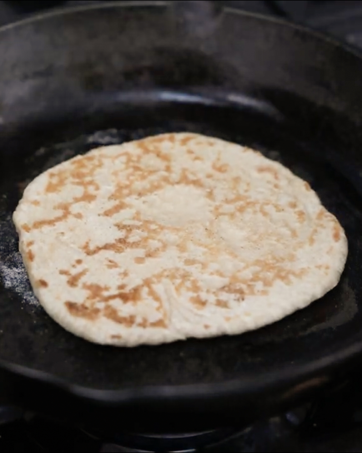 cooking naan on skillet