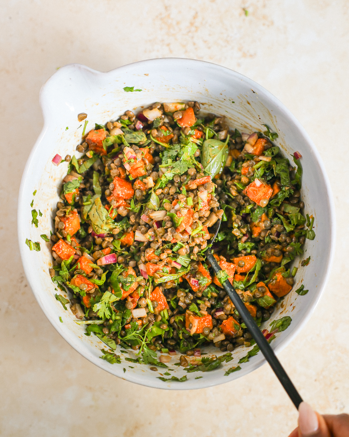 overhead stirring salad in mixing bowl