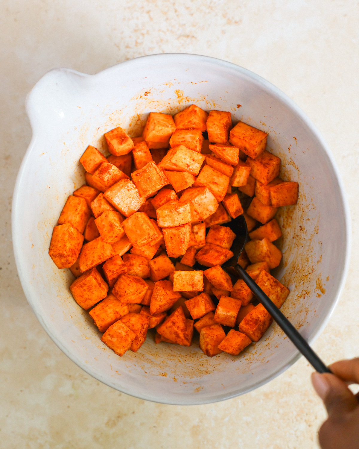 overhead tossing sweet potatoes in spices