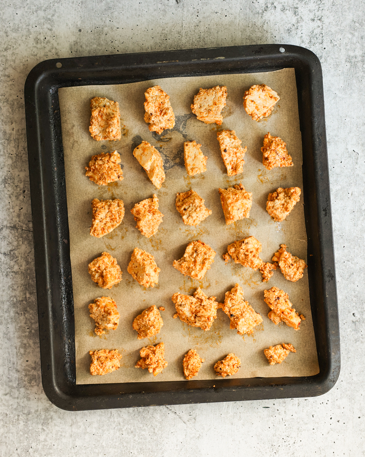 overhead of marinated tofu on baking sheet