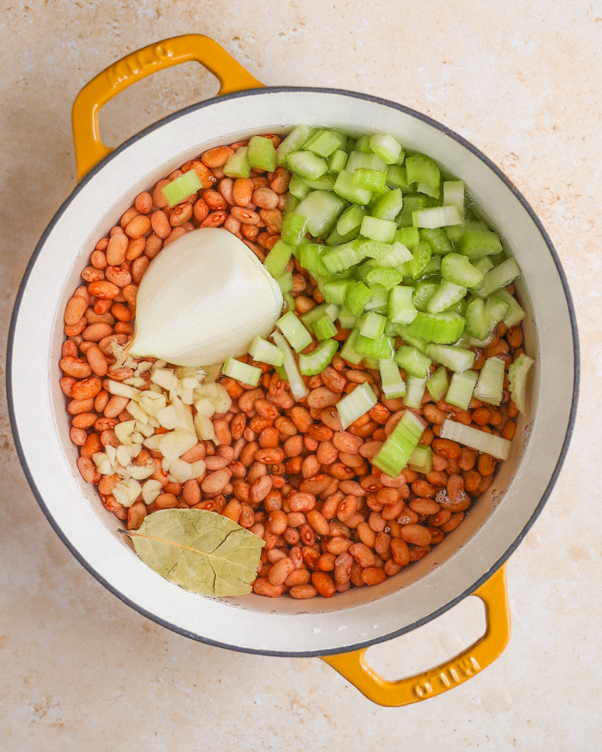 overhead beans in pot with aromatics