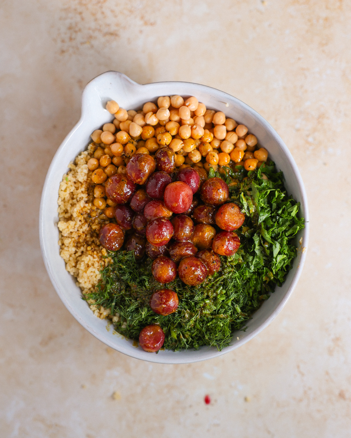overhead of bulgur salad ingredients in mixing bowl