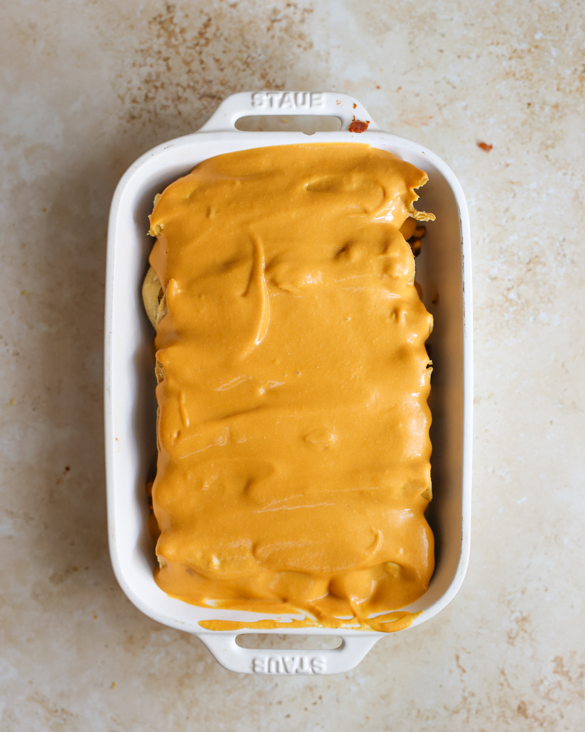 Overhead cheese sauce on enchiladas