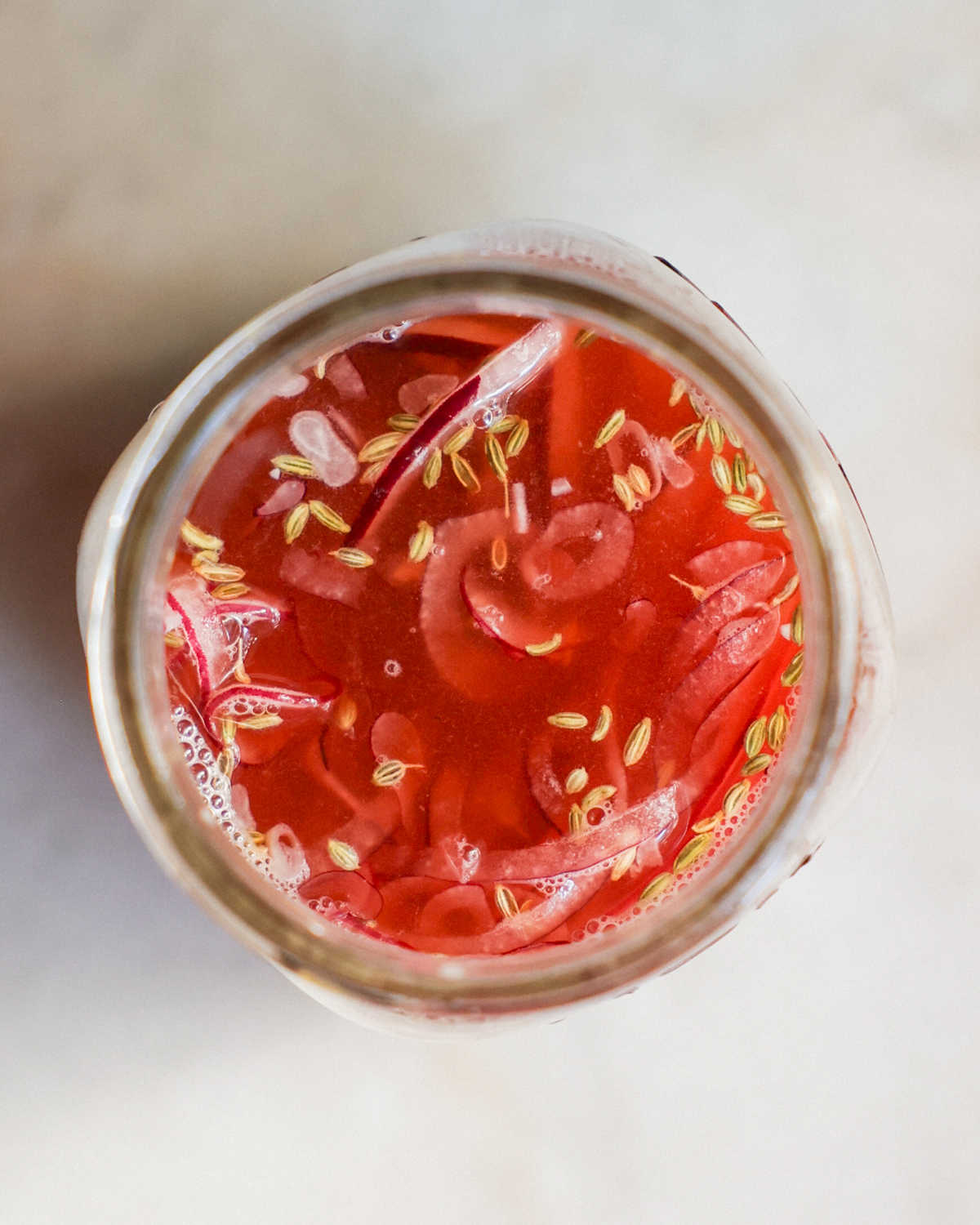 overhead of onions in jar with pickling liquid