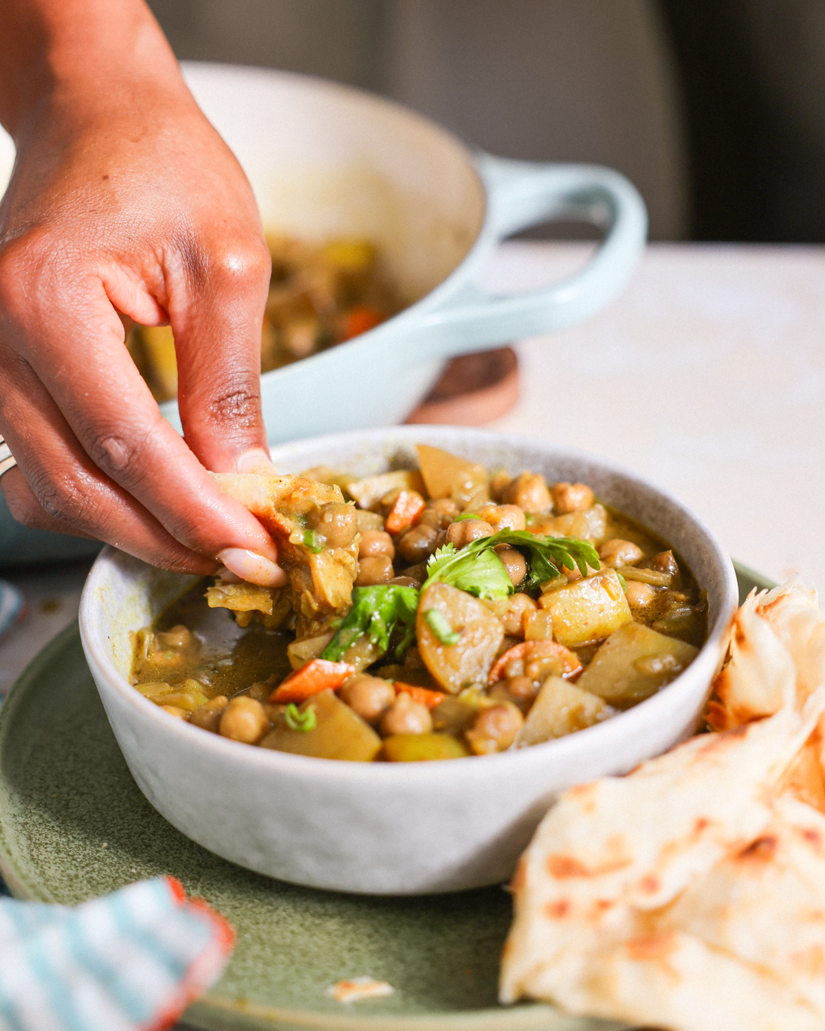 Dipping roti in jamaican curry