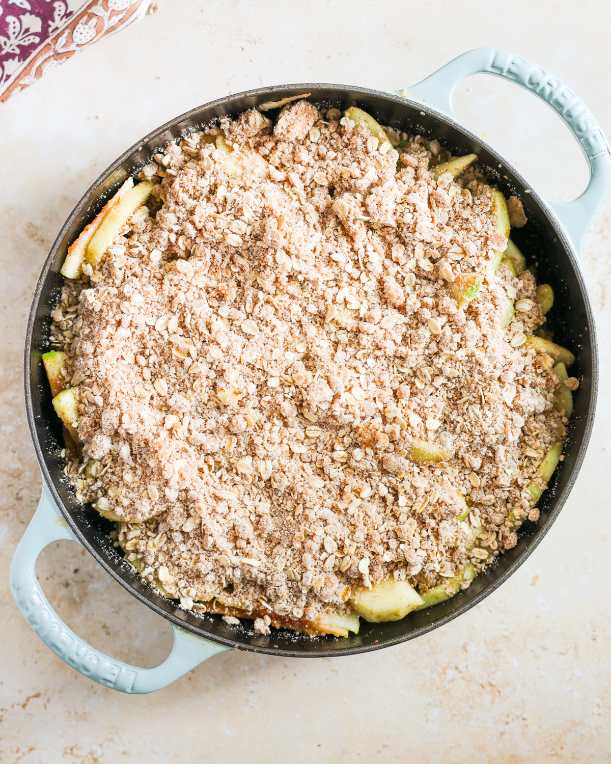 overhead apples topped with crumble topping in skillet