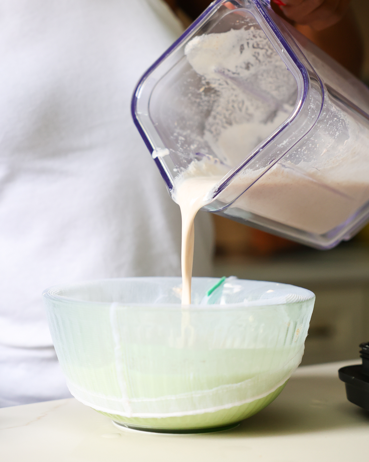 pouring almond milk into nut milk bag