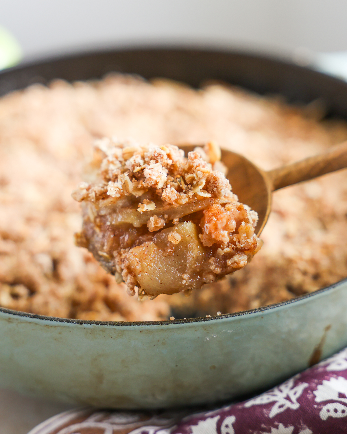 spoonful of apple crisp emerging from the skillet