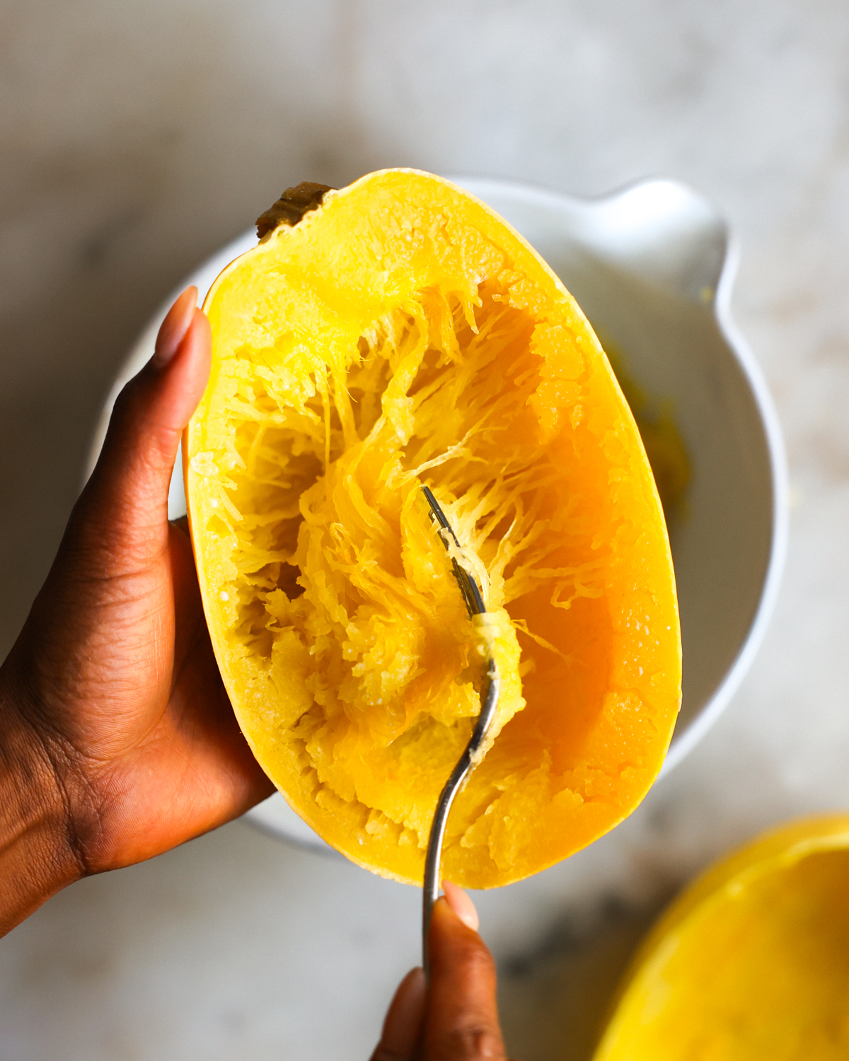 using a fork to scoop spaghetti squash