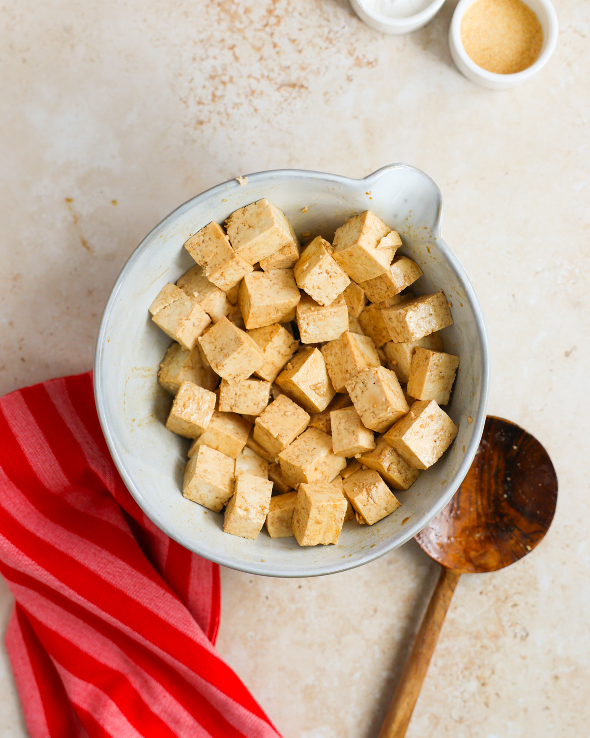 overhead tofu in bowl tossed with soy sauce