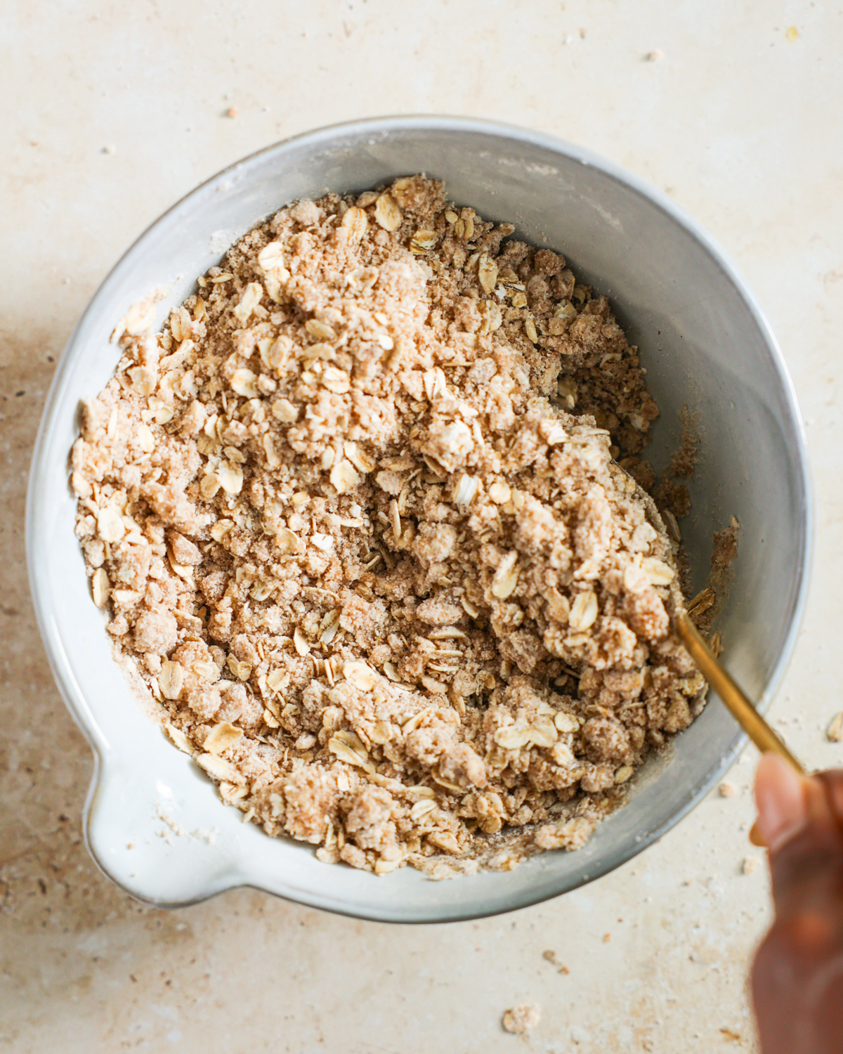overhead stirring the butter into the oat crumble topping