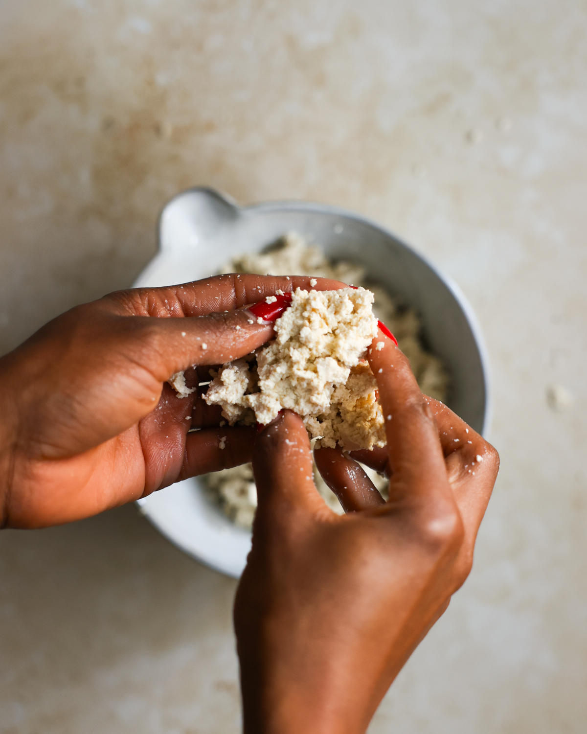 overhead crumbling tofu in hands