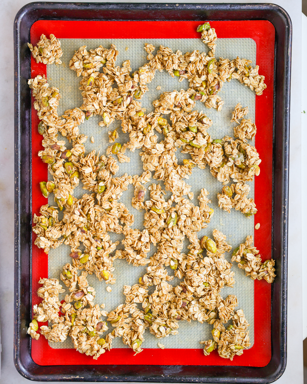 granola spread on baking sheet