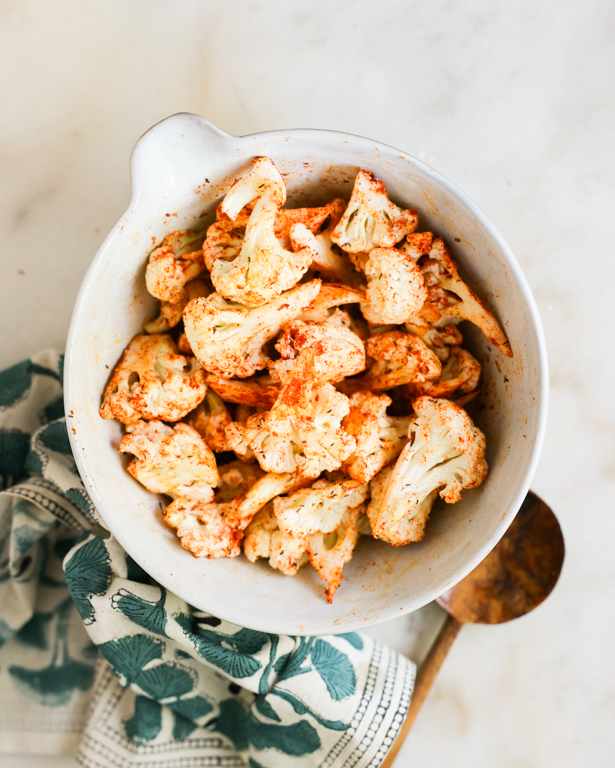 seasoned cauliflower in mixing bowl