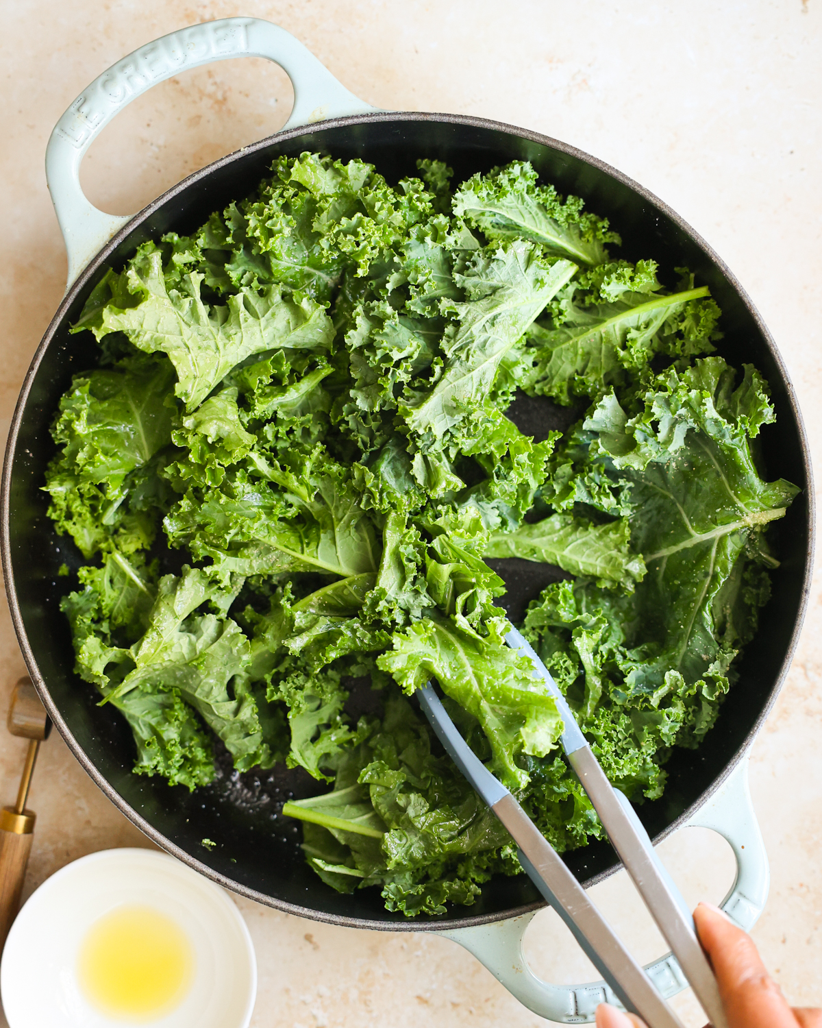 overhead tossing kale with spices