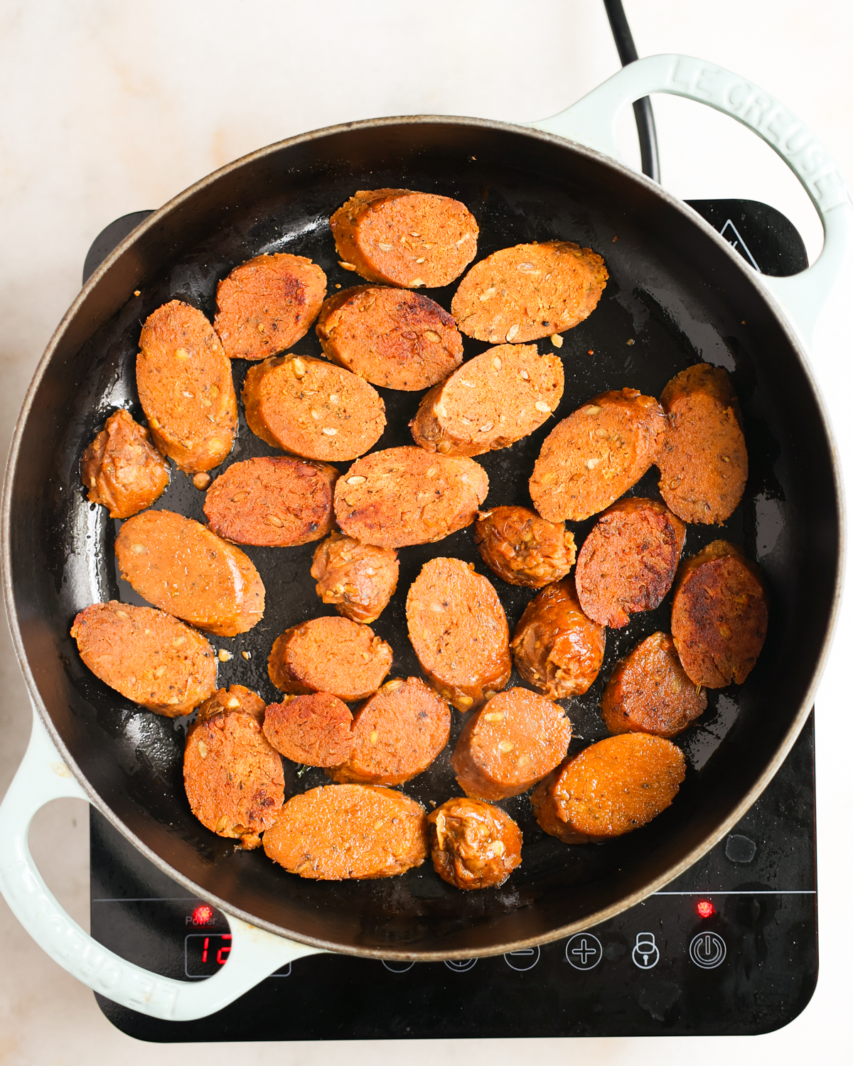 overhead of vegan sausages pan frying 