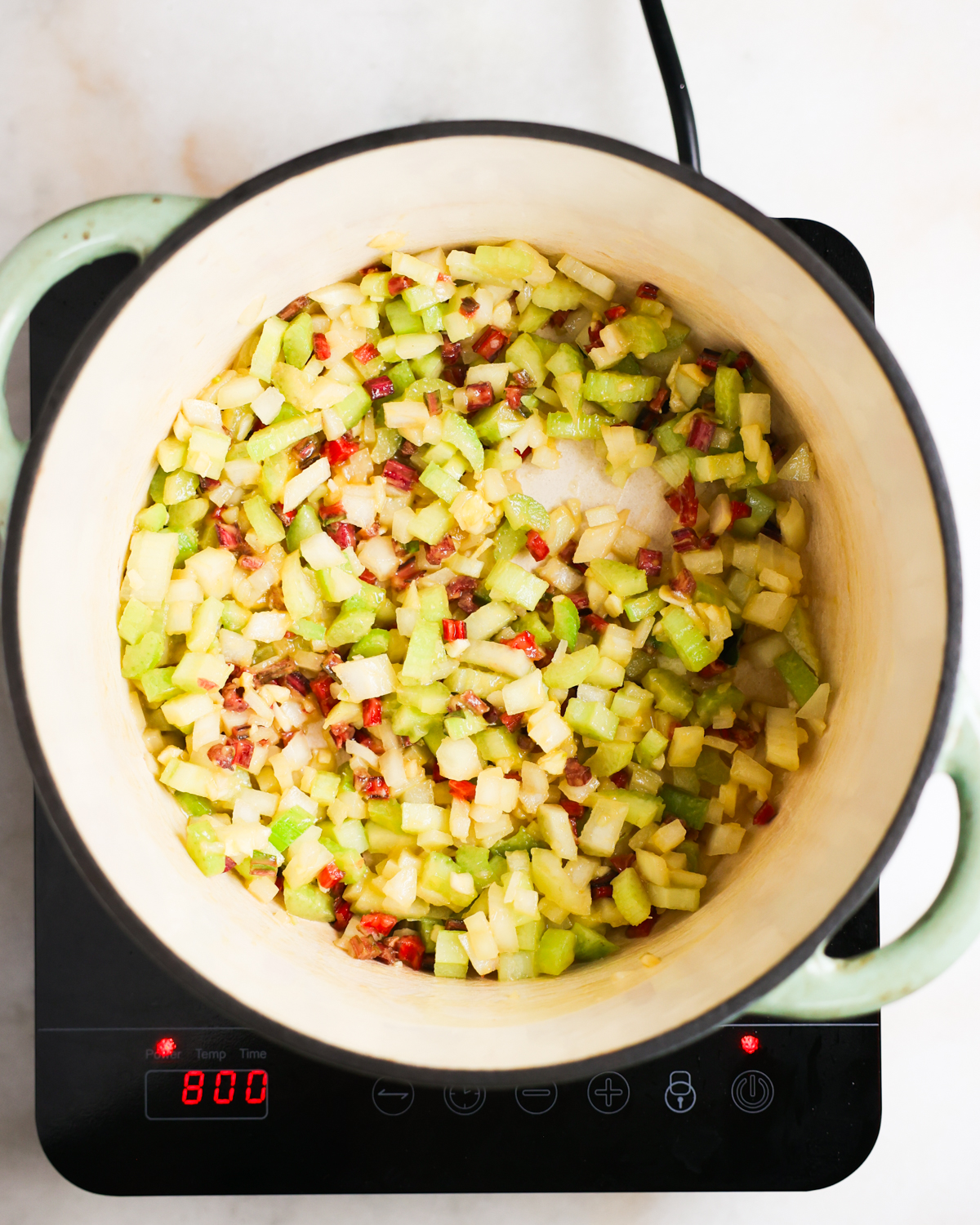 overhead of aromatics sautéing in a pot