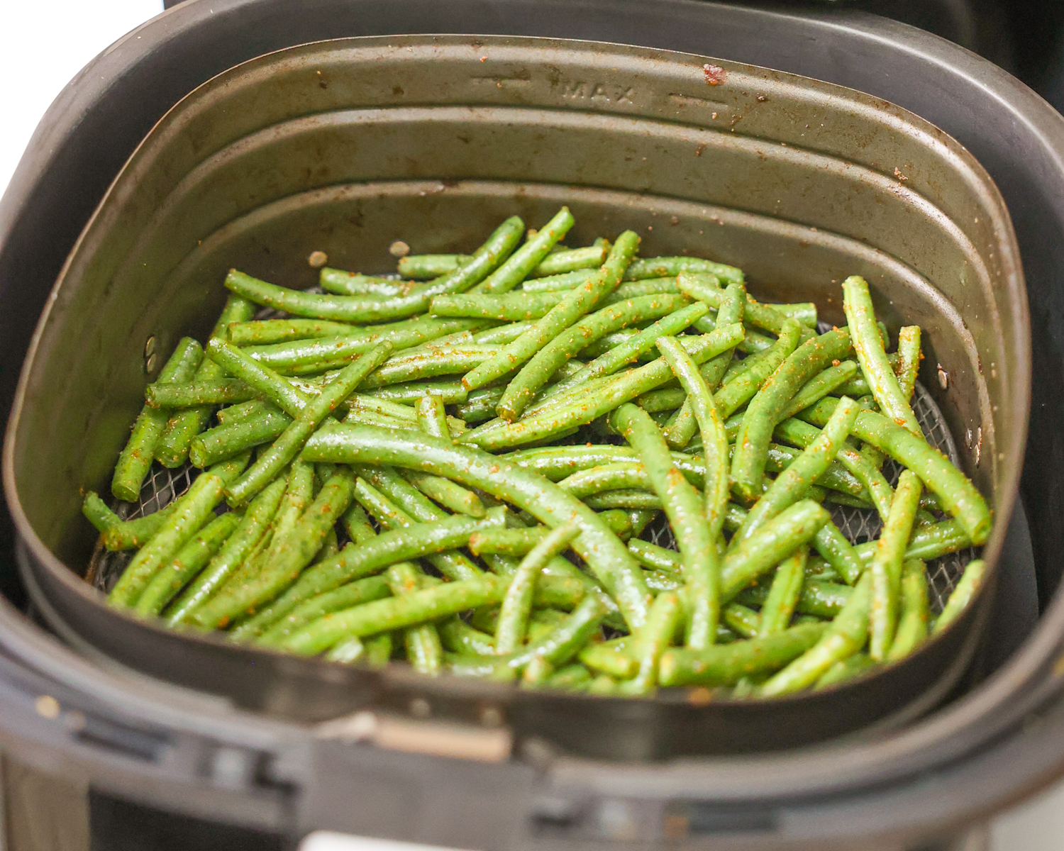 Green beans in the air fryer basket.