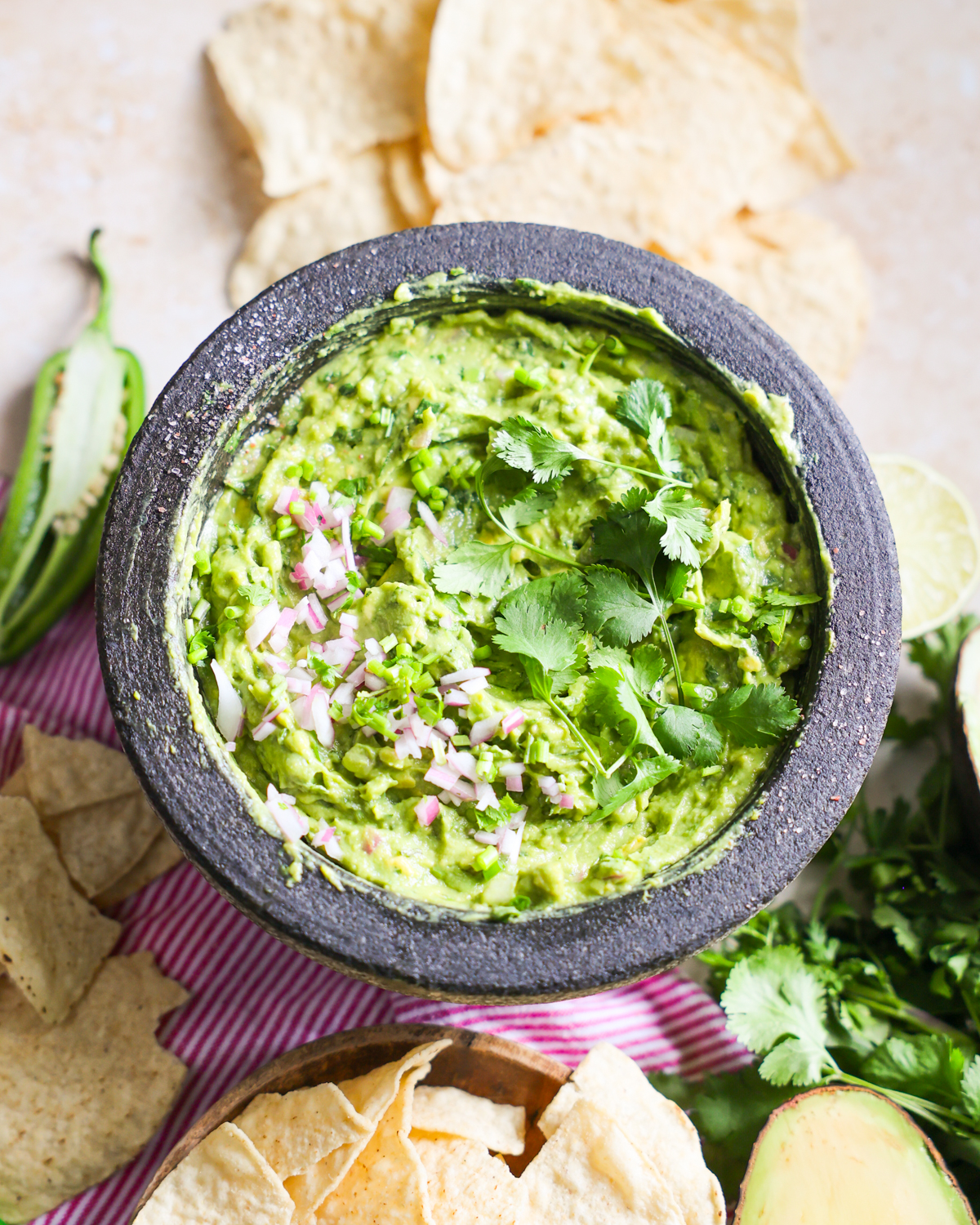 Guacamole garnished with cilantro and red onions.