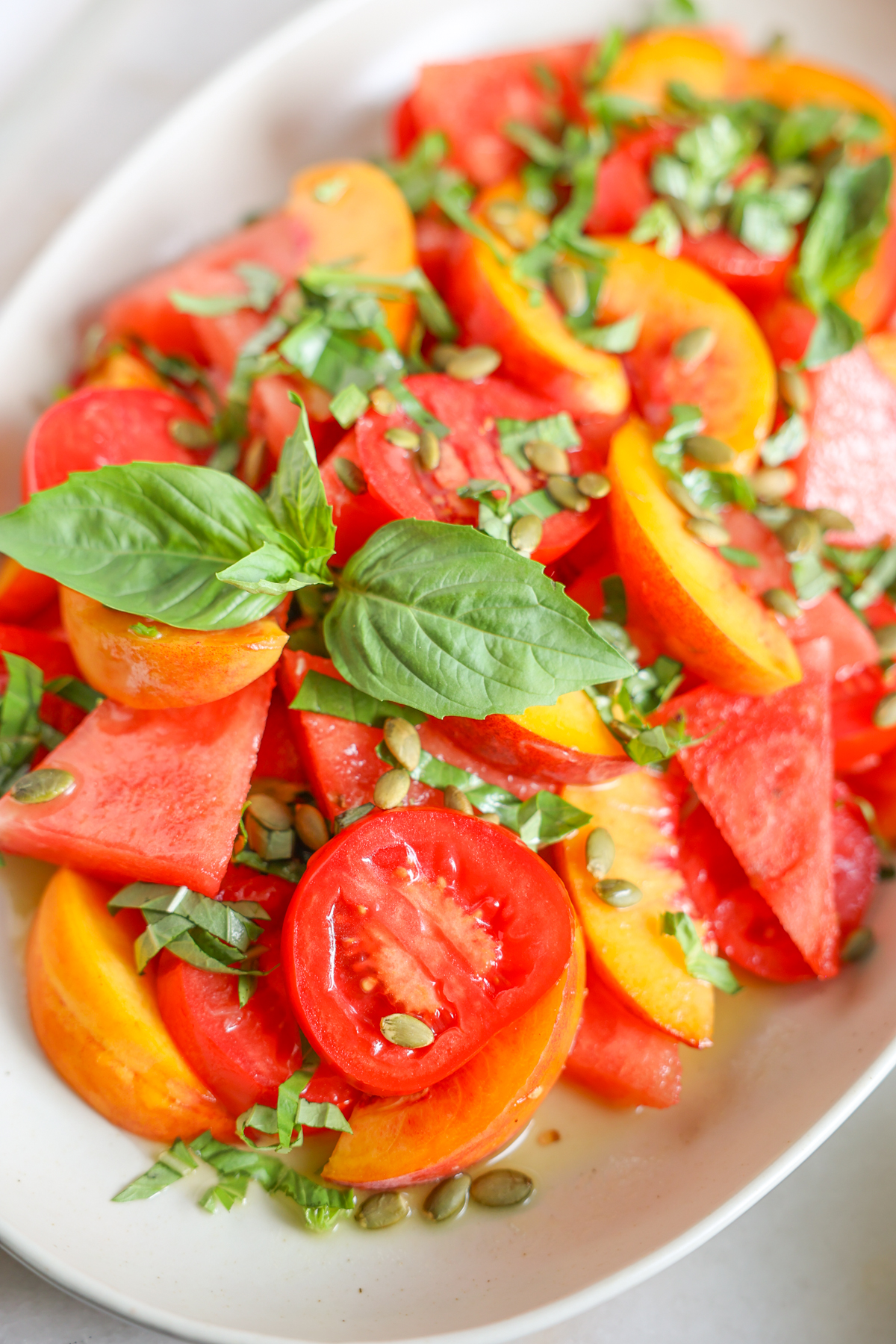 Peach and watermelon salad on a white serving platter.