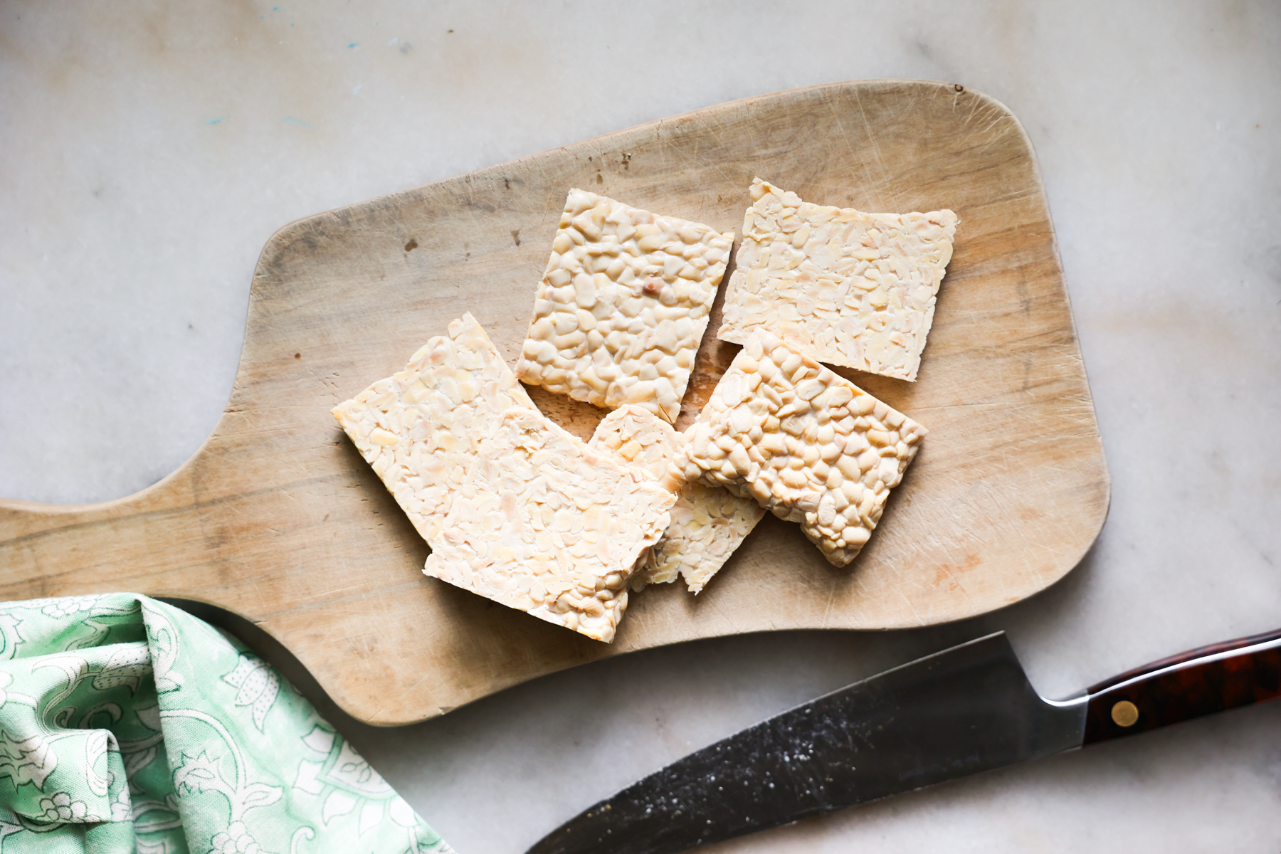 Sliced tempeh on cutting board.