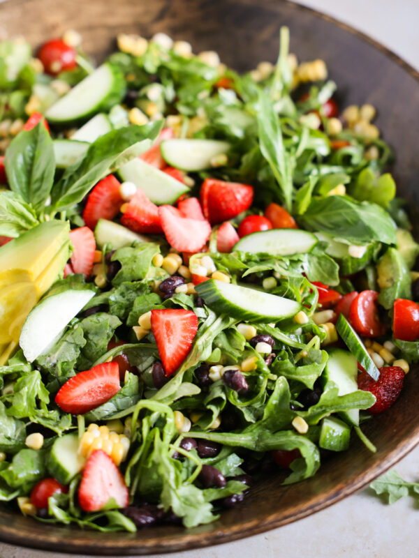 Easy summer salad with strawberries, tomatoes, corn, and arugula.