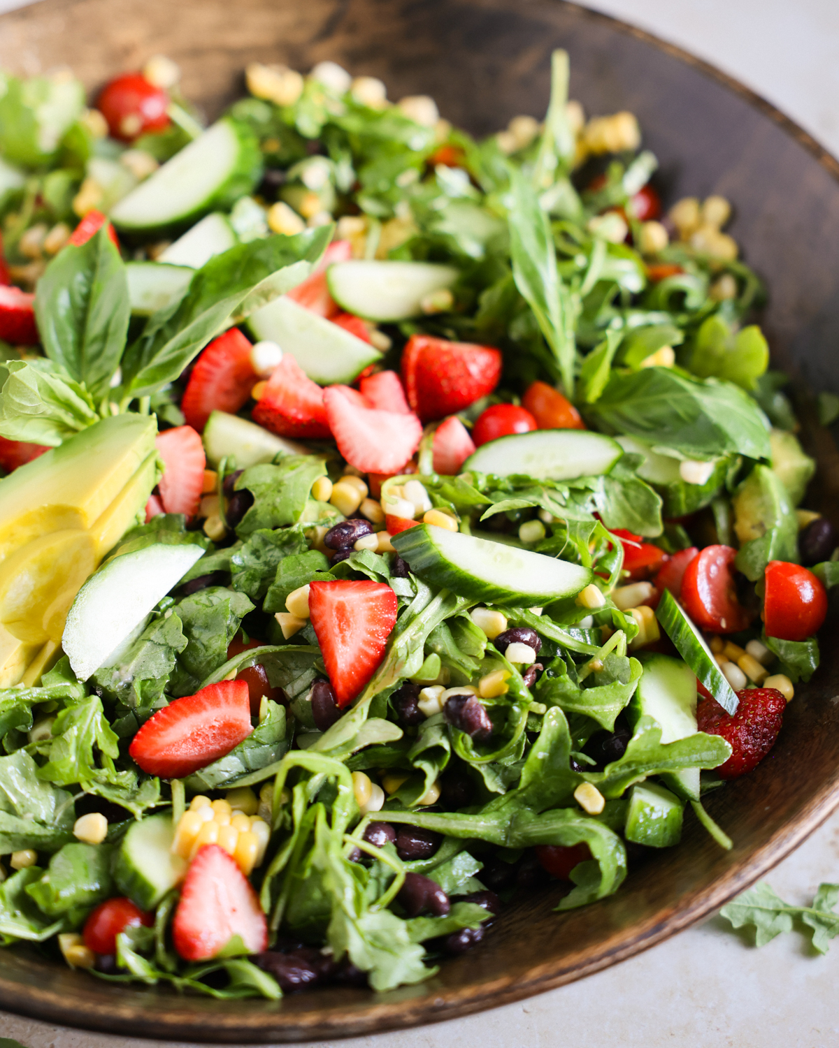 Easy summer salad with strawberries, tomatoes, corn, and arugula.