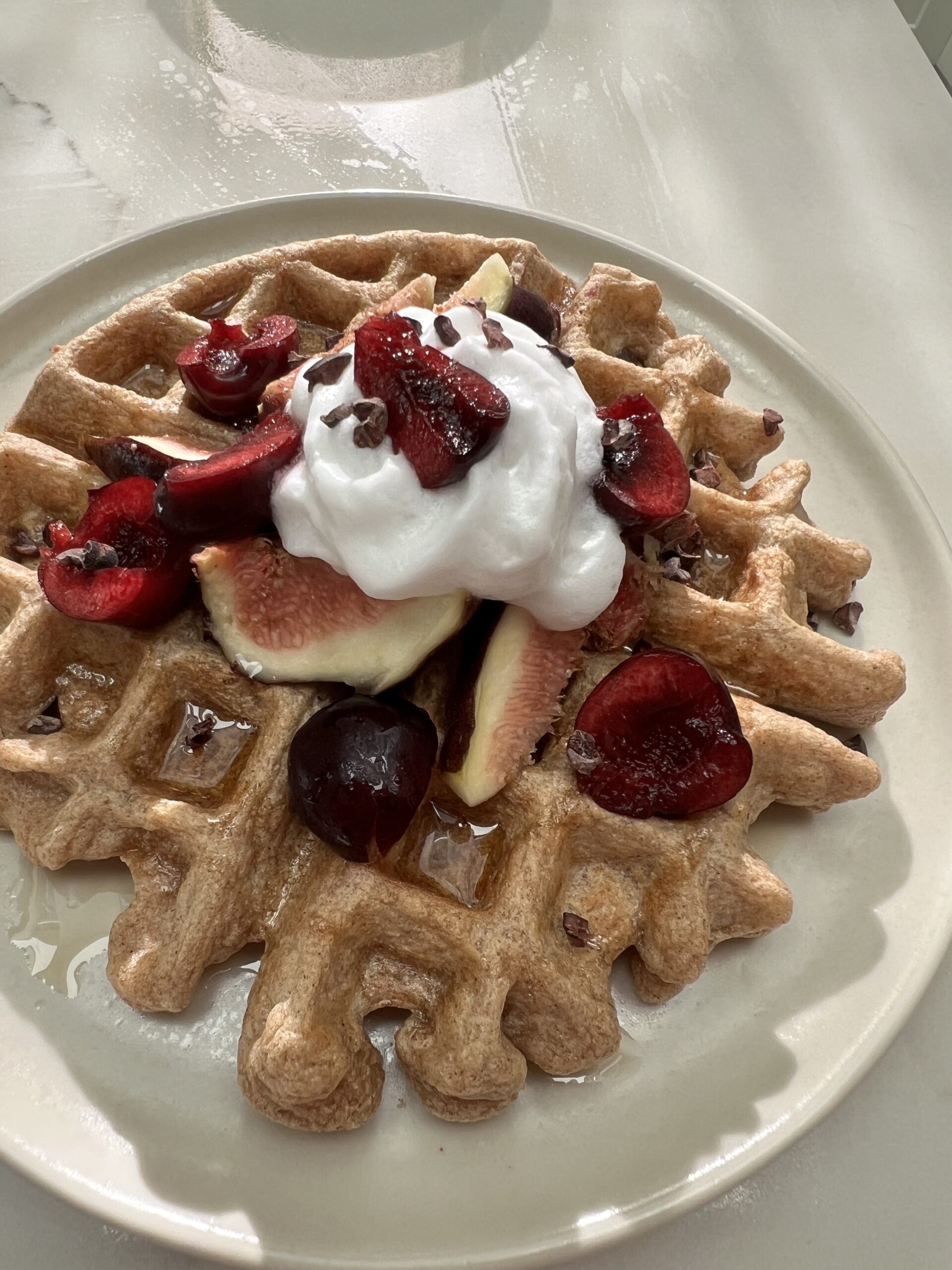 Jenné's vegan waffles topped with cherries and whipped cream.