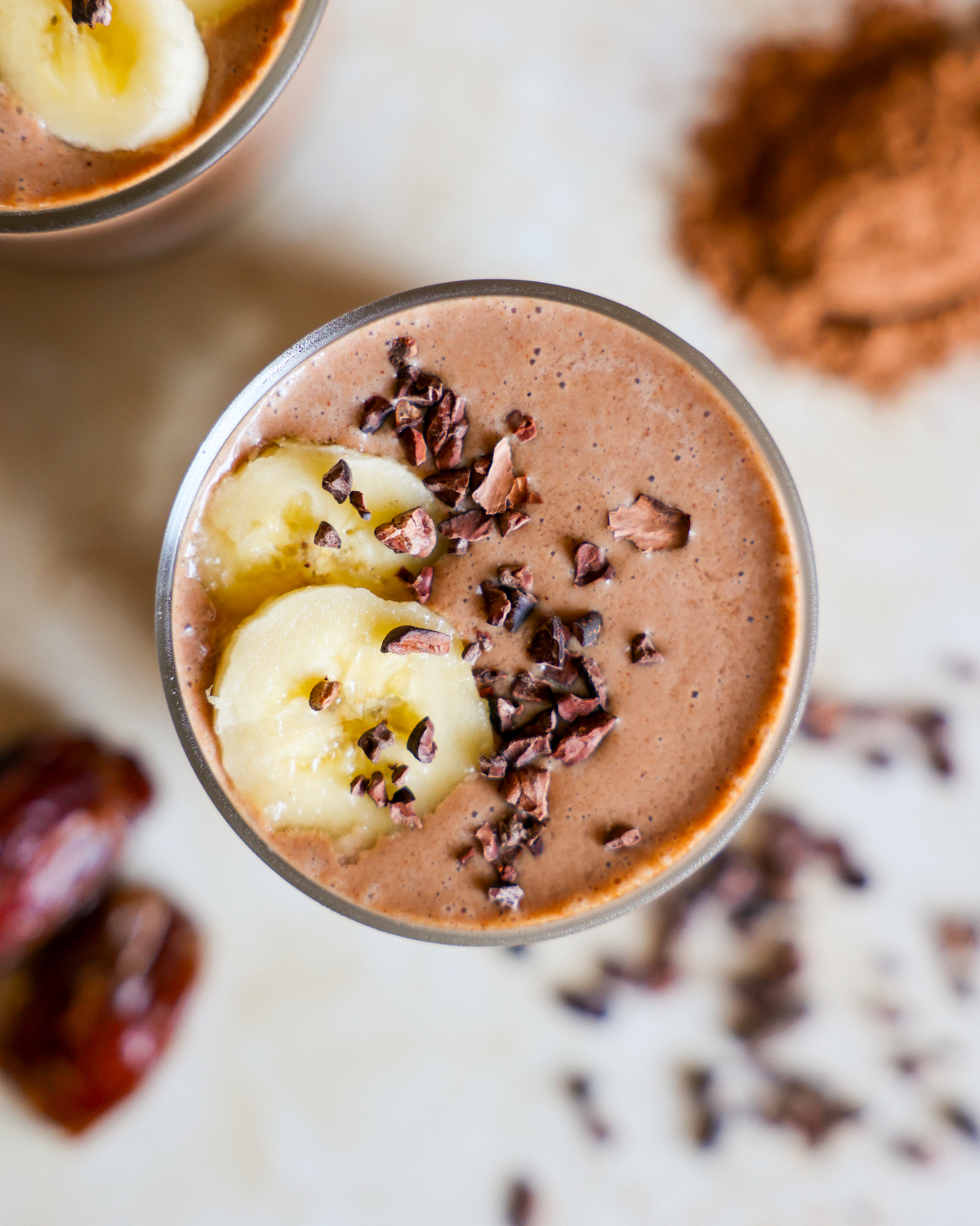 Creamy chocolate smoothie in a glass with cacao nibs.