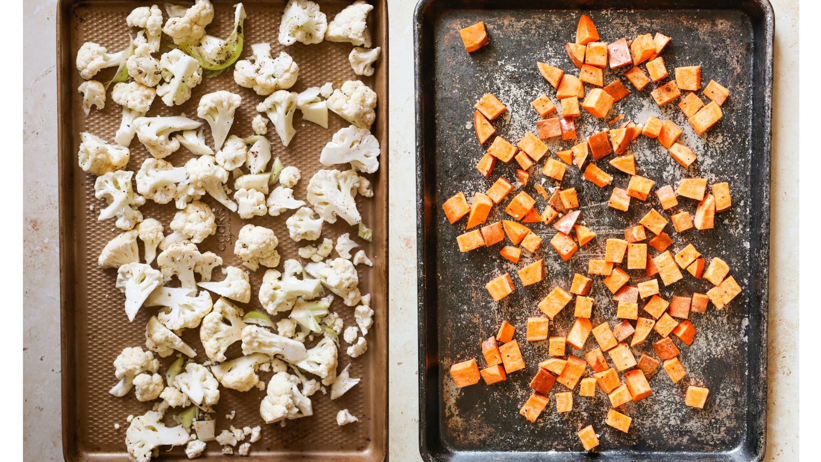Raw cauliflower and raw sweet potatoes on baking sheets.